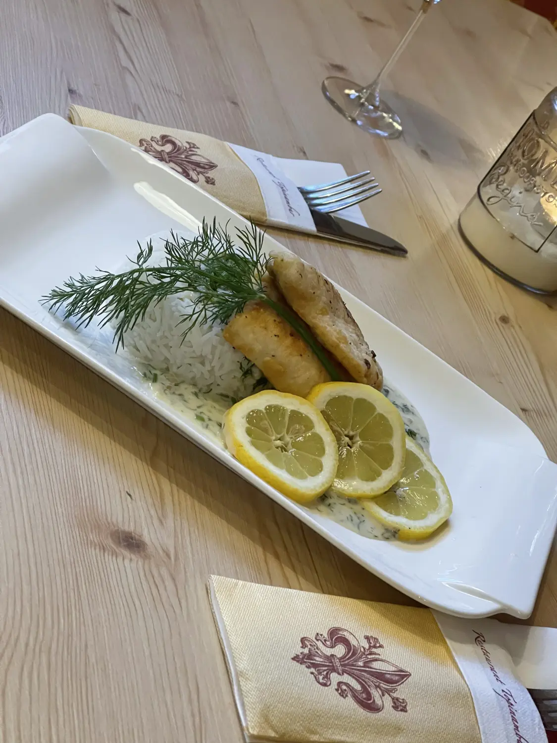 Ein Tellergericht mit einem ganzen gebratenen oder gegrillten Fisch vom Restaurant Topinambur