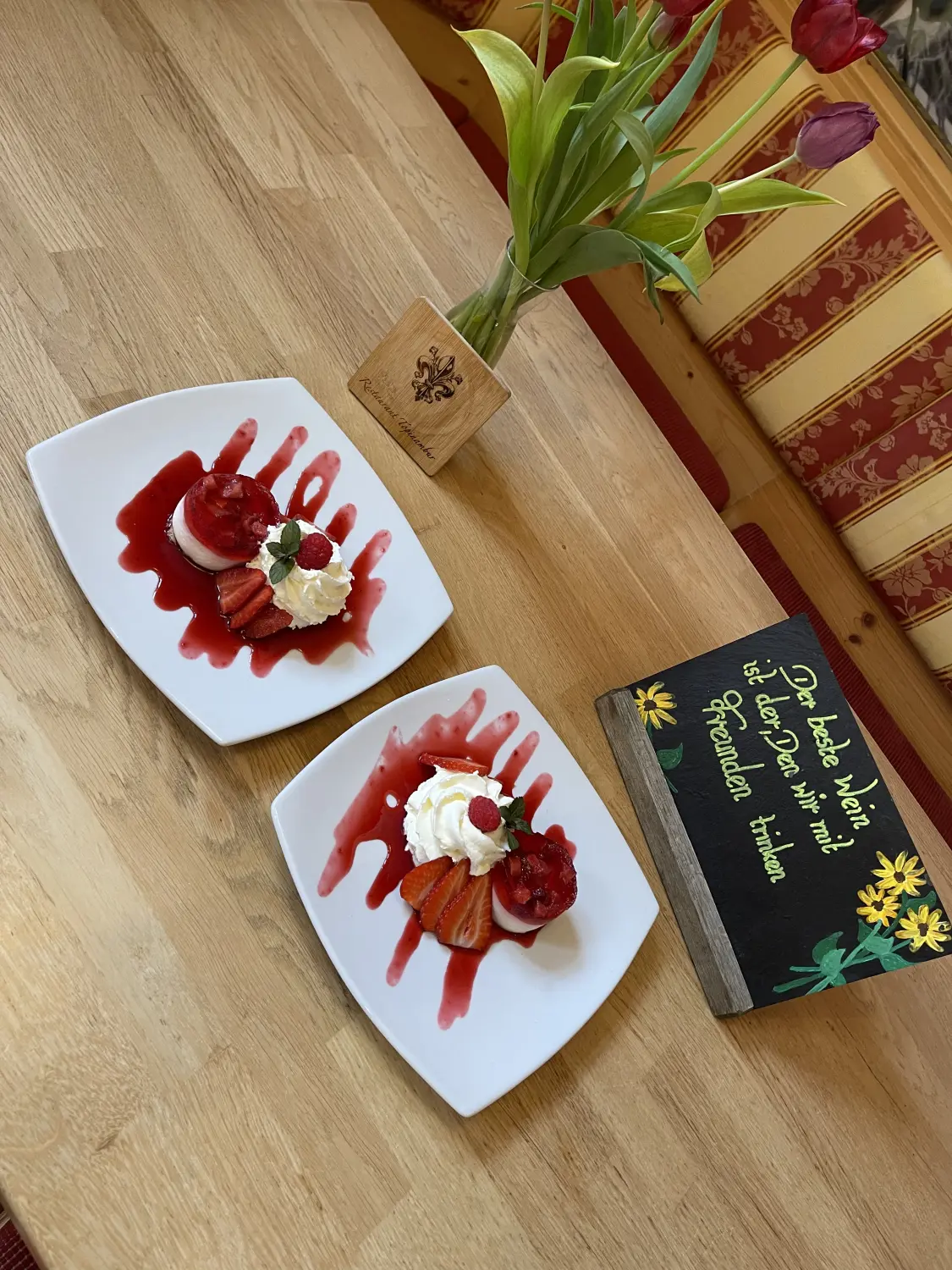 Ein Erdbeerkuchen oder ein ähnliches Dessert mit Schlagsahne und frischen Erdbeeren vom Restaurant Topinambur