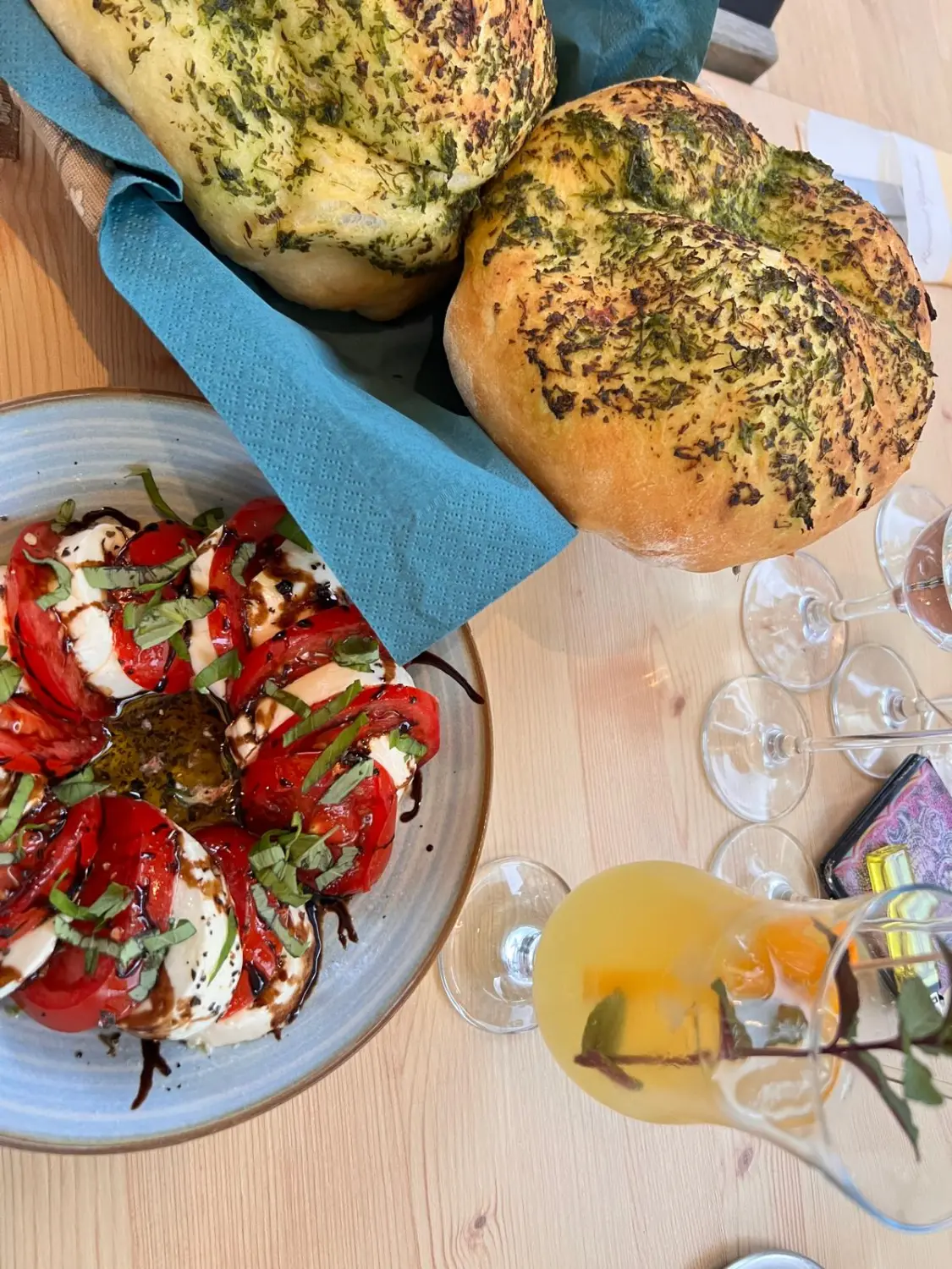 Caprese-Salat, Kräuterbrot, Getränk und Gläser Restaurant Topinambur