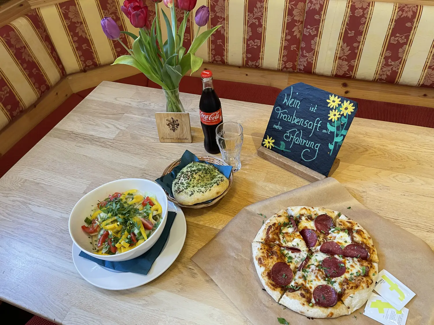Ein Hähnchen-Gemüse-Gericht, serviert in einer weißen Schüssel. Und Pizza vom Restaurant Topinambur